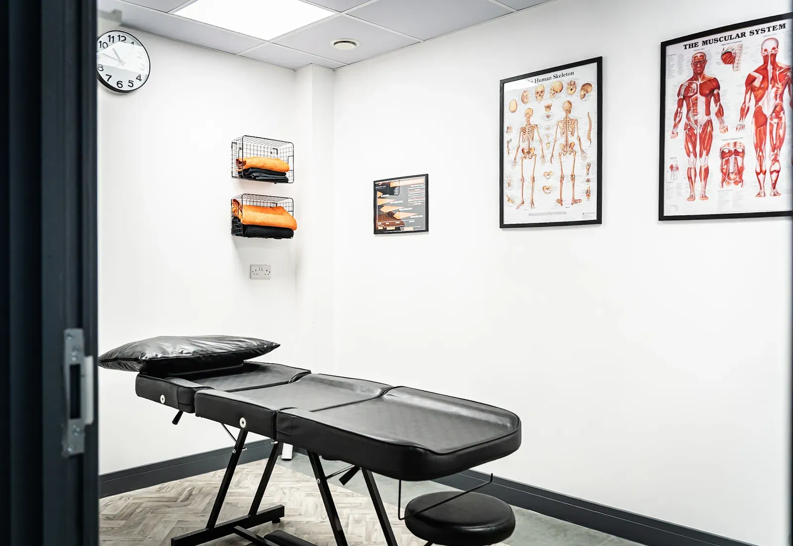 Sports therapy room with anatomy charts and treatment table