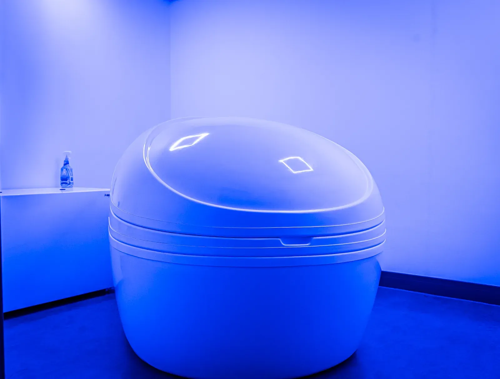 Open sensory deprivation float tank with blue lighting