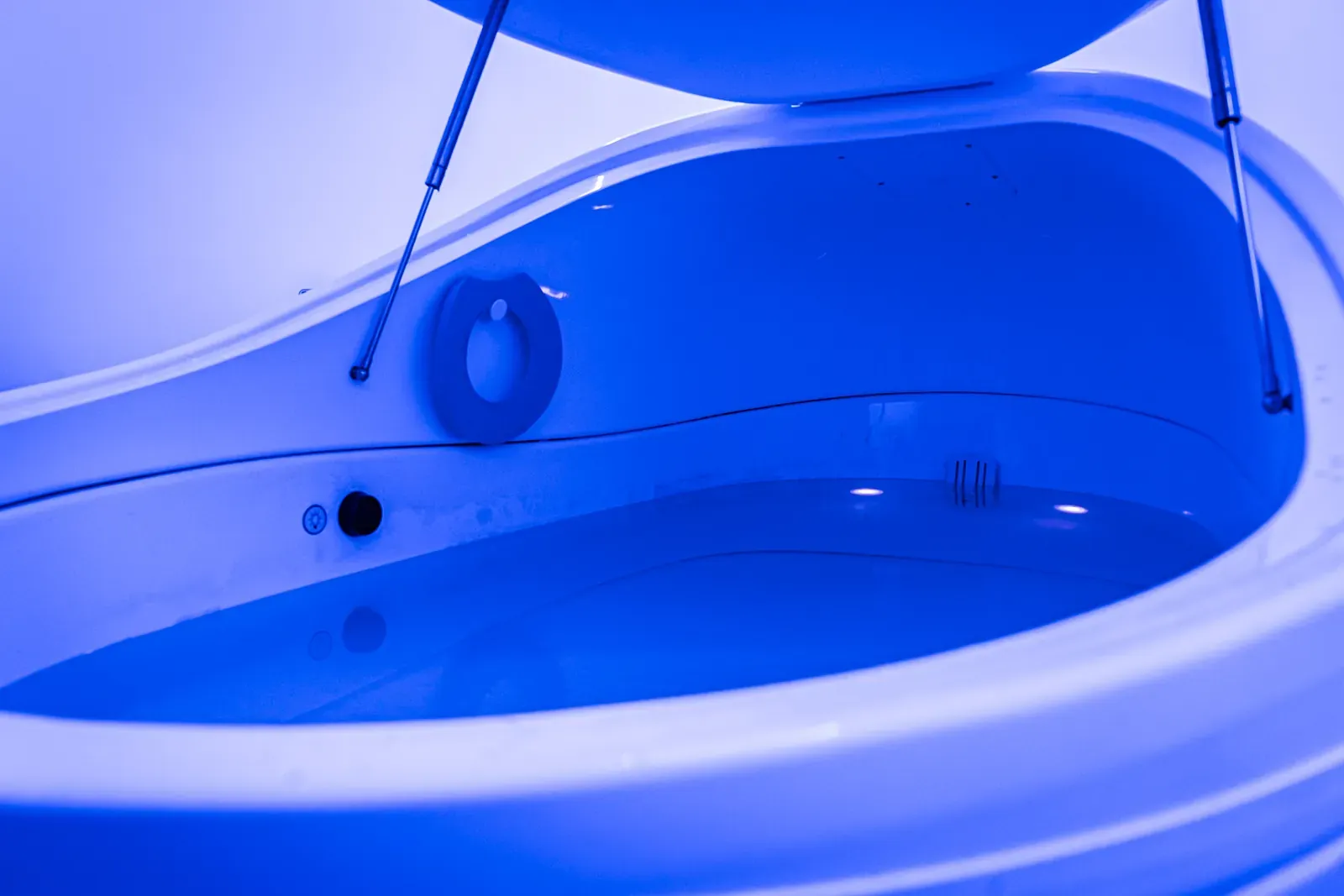 Sensory deprivation float tank with ambient blue lighting